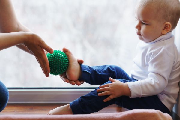 Mamma massaggia i piedi del bambino