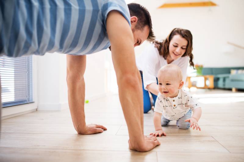 famiglia con bambino che gattona