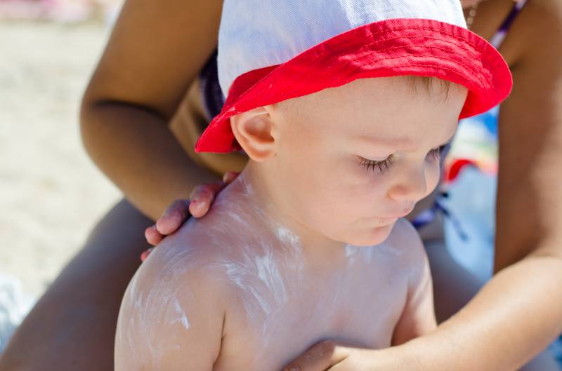 Bambino con crema solare e cappello