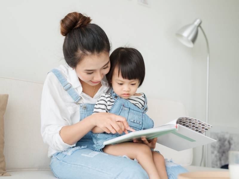 Mamma legge libro alla figlia