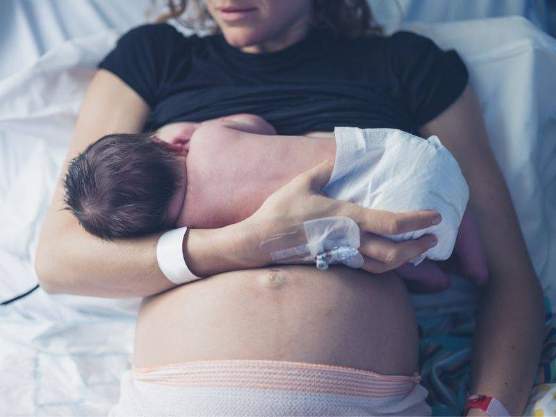 Madre che allatta al seno appena nato in ospedale