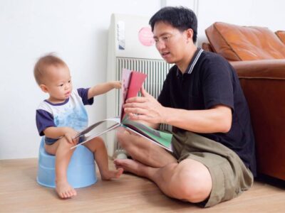 Papà legge il libro al bambino sul vasino