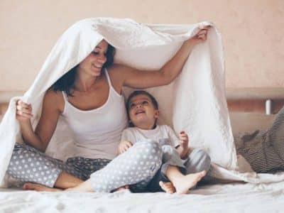 mamma con bambino sotto un lenzuolo