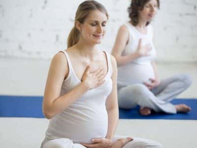 Donna incinta fa esercizi di respirazione yoga