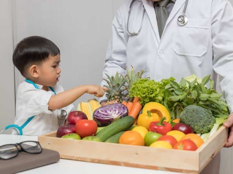 Bambino che impara sulla nutrizione con il medico